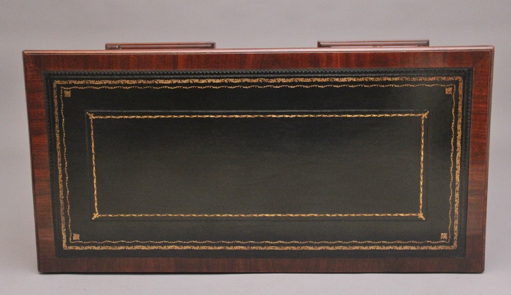 An early 19th-century mahogany kneehole desk with a dark leather writing top, multiple side drawers with circular brass ring handles, and a central recessed cupboard door. View IX