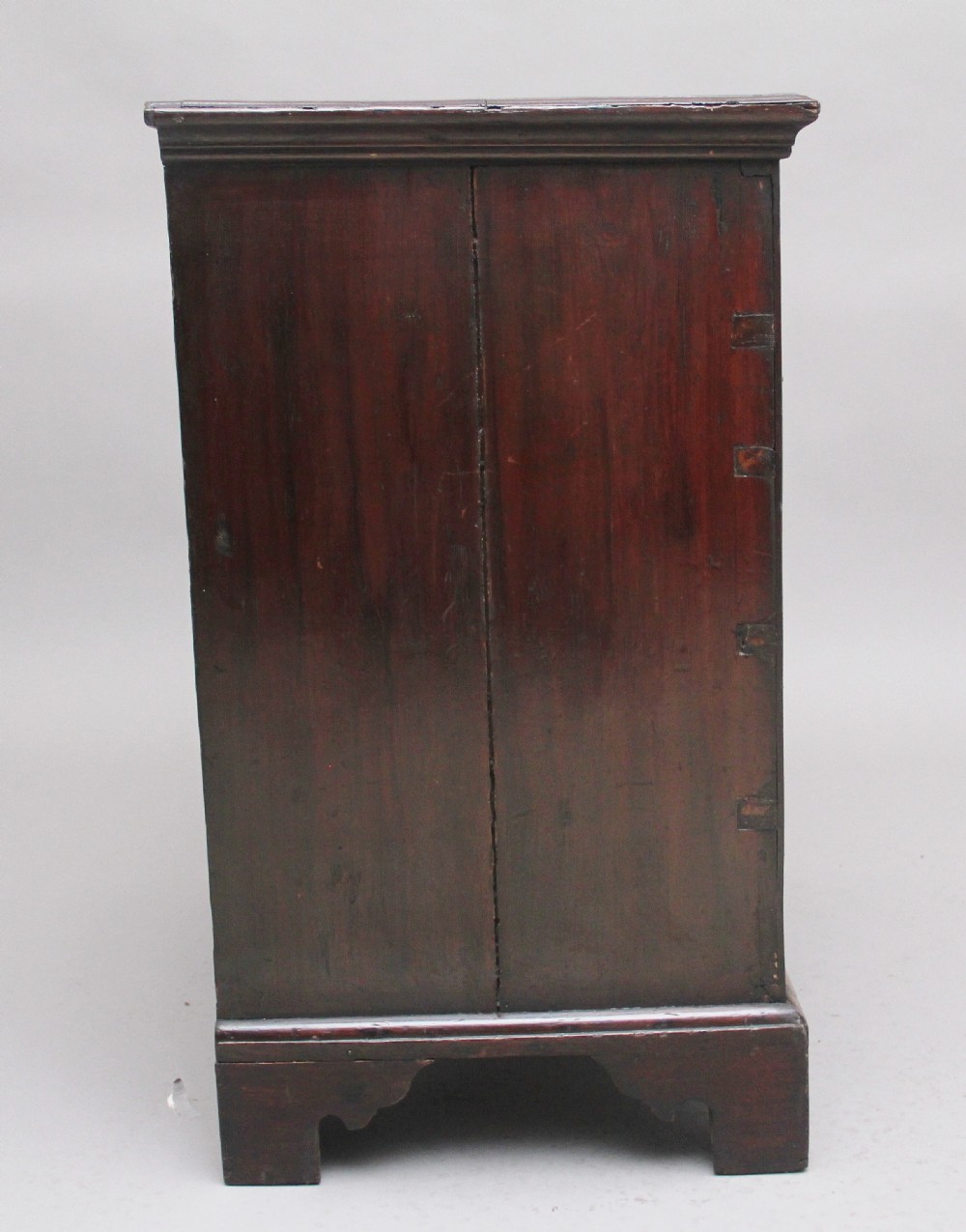 An 18th-century Georgian dark oak chest of drawers featuring five horizontal graduated drawers with brass swan-neck handles, brass escutcheons, and bracket feet. View VIII