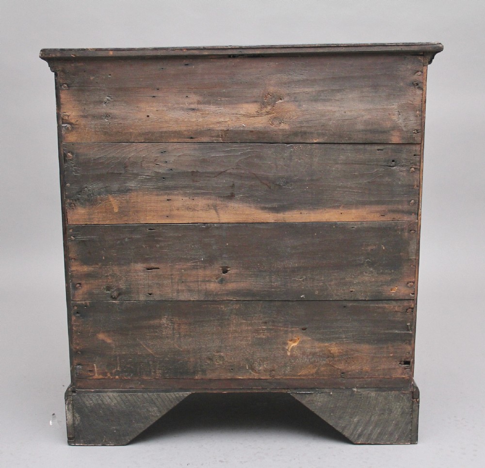 An 18th-century Georgian dark oak chest of drawers featuring five horizontal graduated drawers with brass swan-neck handles, brass escutcheons, and bracket feet. View IX