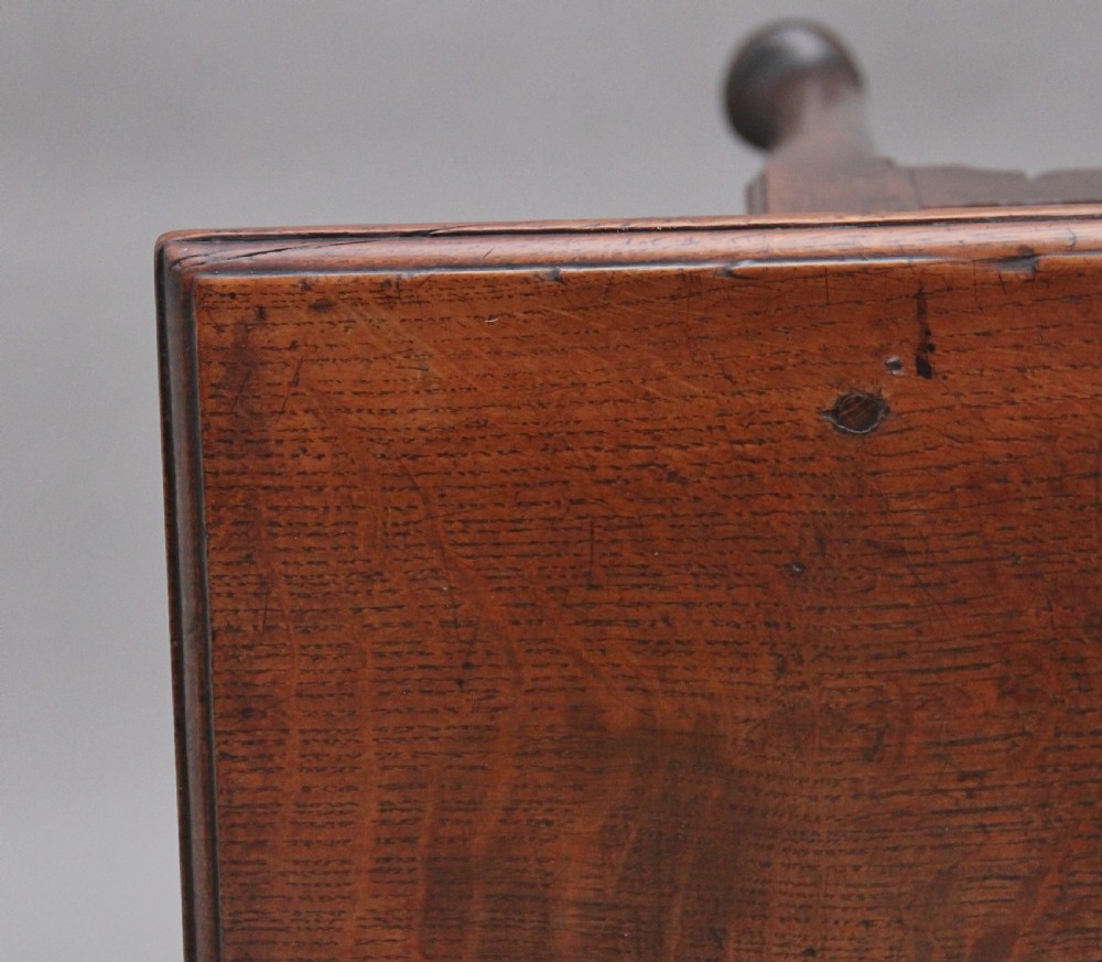 An 18th-century dark oak side table featuring a central drawer, small side drawers, pierced brass handles, a shaped apron, and turned legs ending in pad feet. View XI