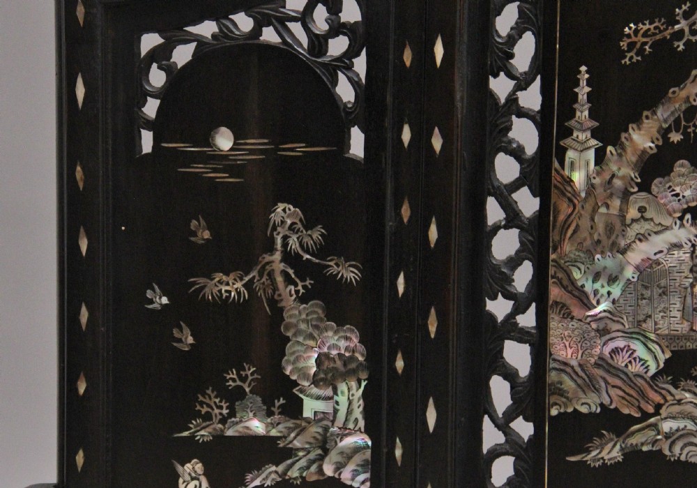A 19th-century Chinese dark hardwood triptych table screen set with carved openwork borders and detailed mother-of-pearl landscape inlays. View VIII