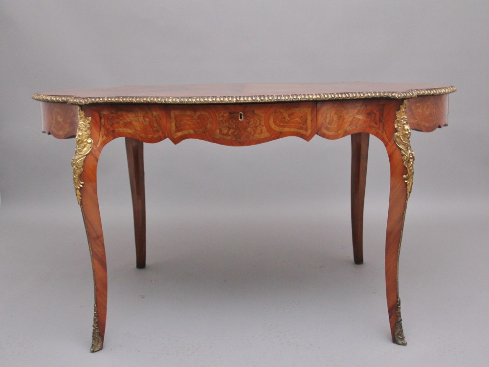 A 19th-century French Rococo style walnut centre table featuring cabriole legs, floral marquetry inlay, and gilded ormolu mounts.