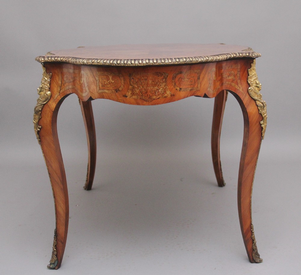 A 19th-century French Rococo style walnut centre table featuring cabriole legs, floral marquetry inlay, and gilded ormolu mounts. View V