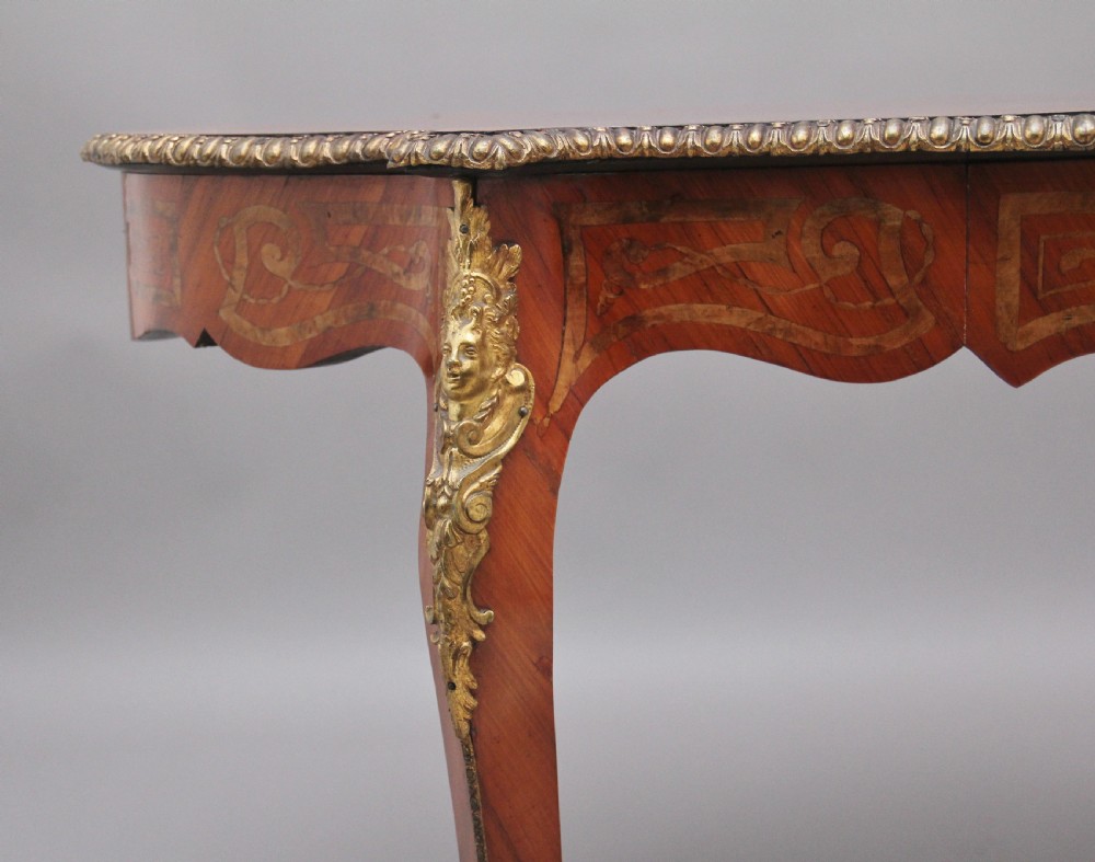 A 19th-century French Rococo style walnut centre table featuring cabriole legs, floral marquetry inlay, and gilded ormolu mounts. View X