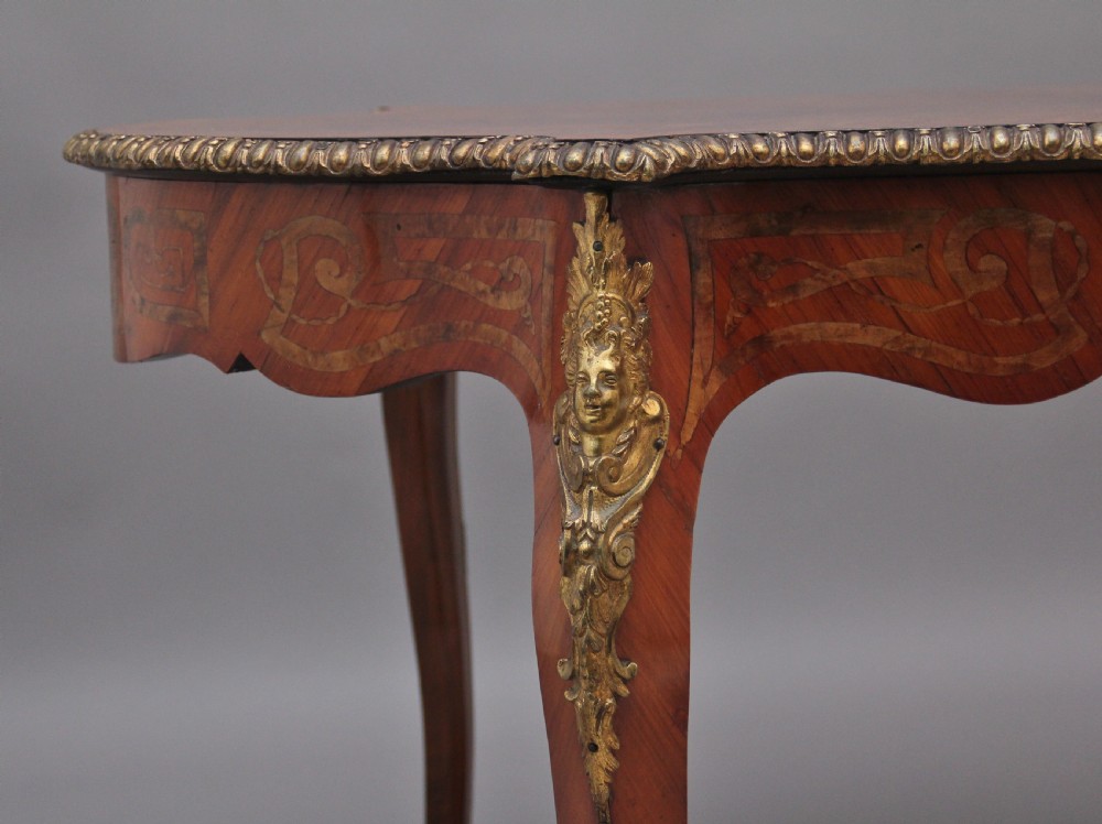 A 19th-century French Rococo style walnut centre table featuring cabriole legs, floral marquetry inlay, and gilded ormolu mounts. View XI