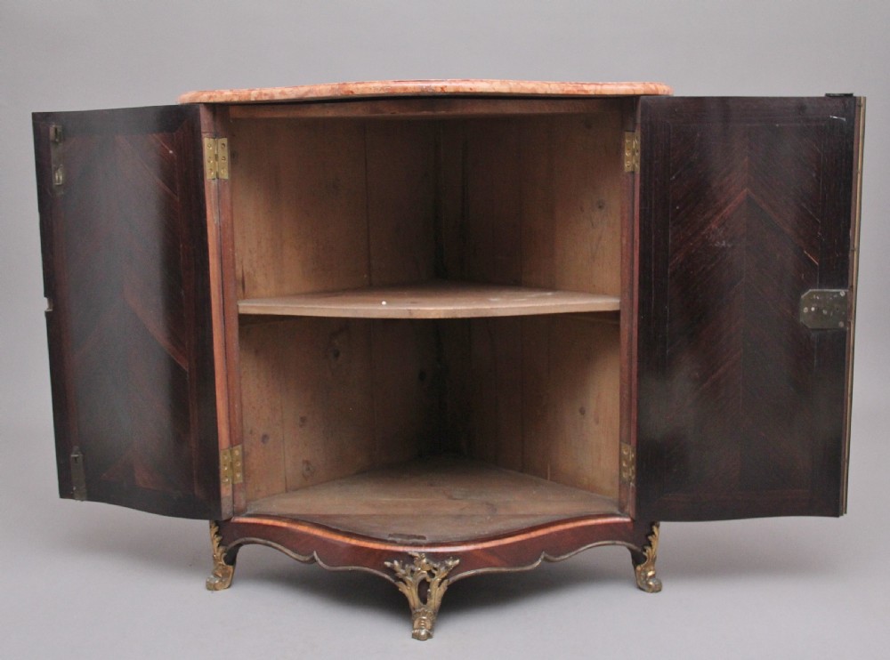 An 18th-century French corner cabinet featuring a curved front with intricate floral marquetry inlay, gilt bronze mounts, and a contoured marble top. View II
