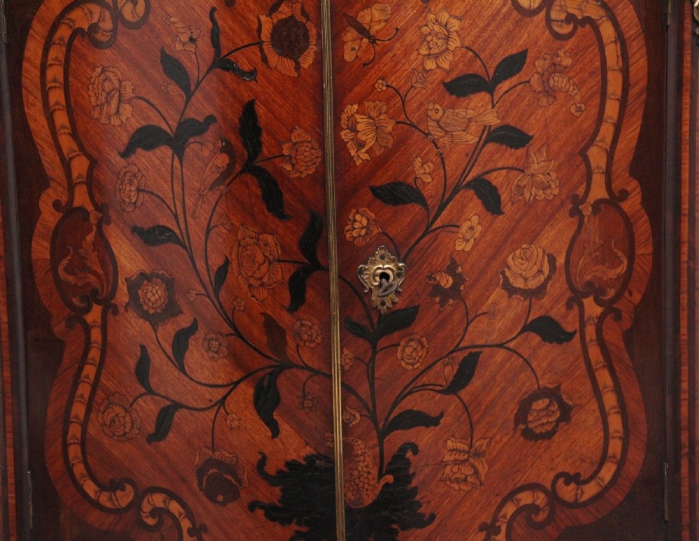 An 18th-century French corner cabinet featuring a curved front with intricate floral marquetry inlay, gilt bronze mounts, and a contoured marble top. View IX