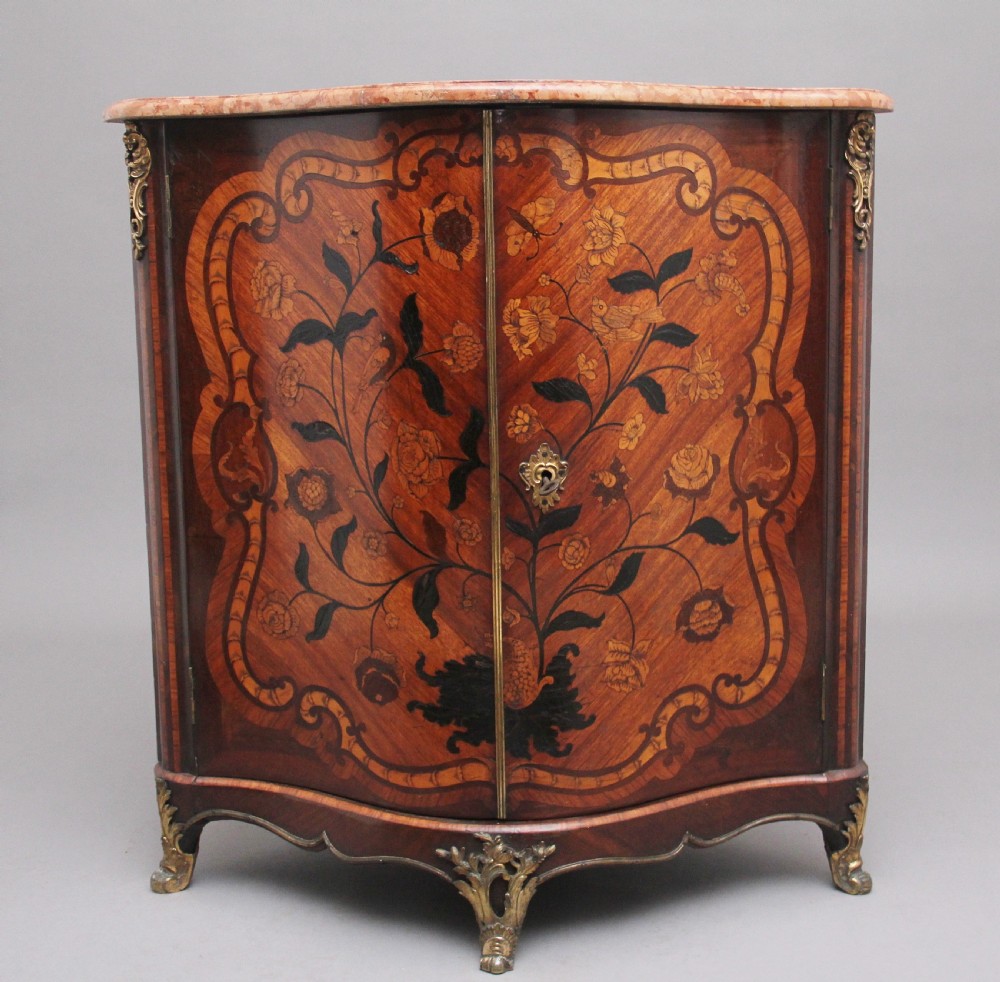 An 18th-century French corner cabinet featuring a curved front with intricate floral marquetry inlay, gilt bronze mounts, and a contoured marble top. View XI