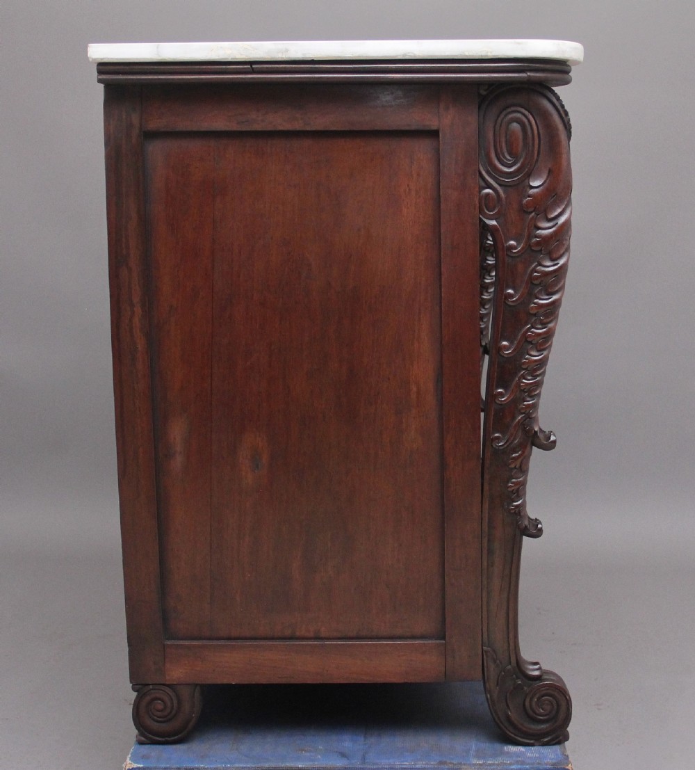 A 19th-century Anglo-Indian dark wood cabinet featuring a white marble top, two carved drawers, and two doors decorated with intricate pierced floral relief motifs. View VII