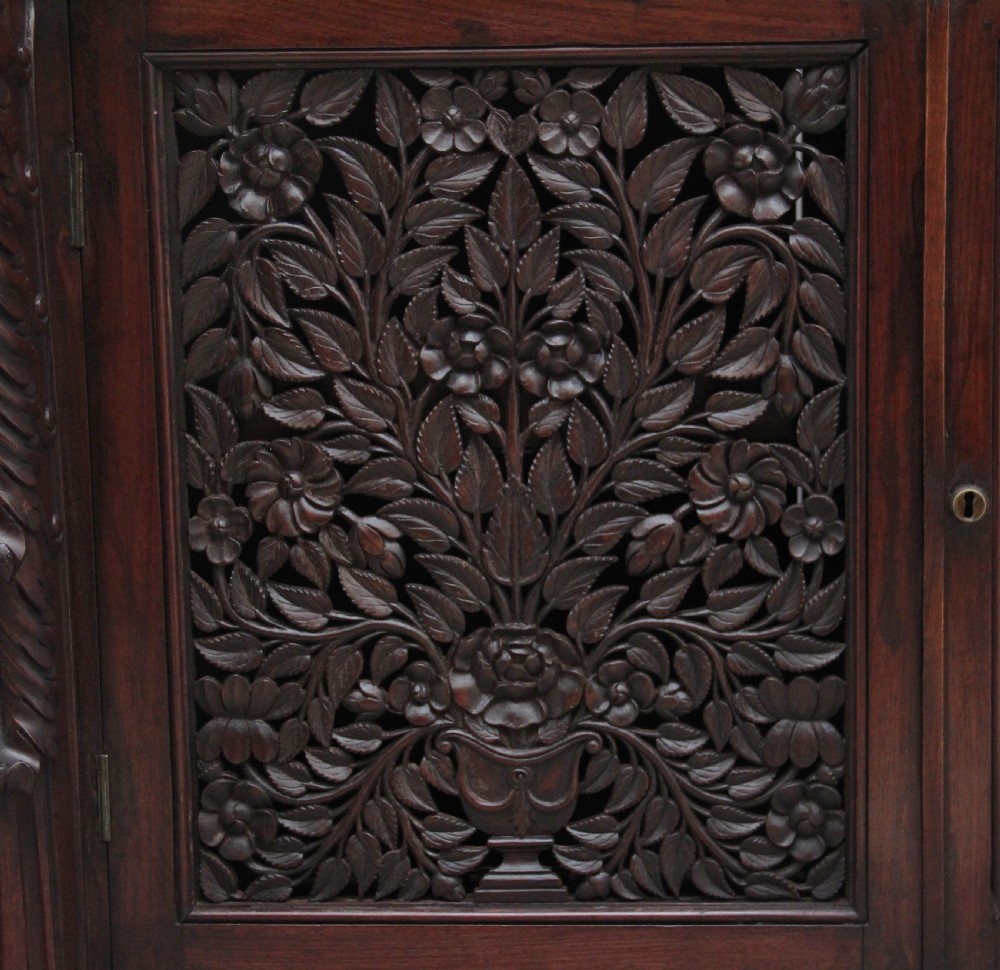 A 19th-century Anglo-Indian dark wood cabinet featuring a white marble top, two carved drawers, and two doors decorated with intricate pierced floral relief motifs. View XIV