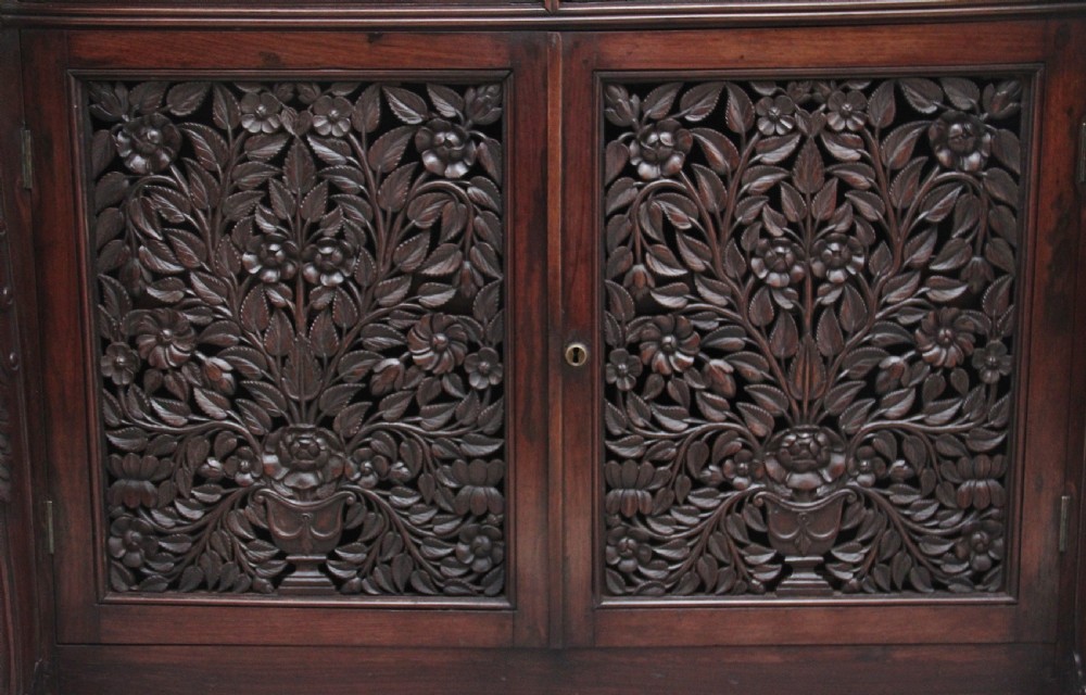 A 19th-century Anglo-Indian dark wood cabinet featuring a white marble top, two carved drawers, and two doors decorated with intricate pierced floral relief motifs. View XV