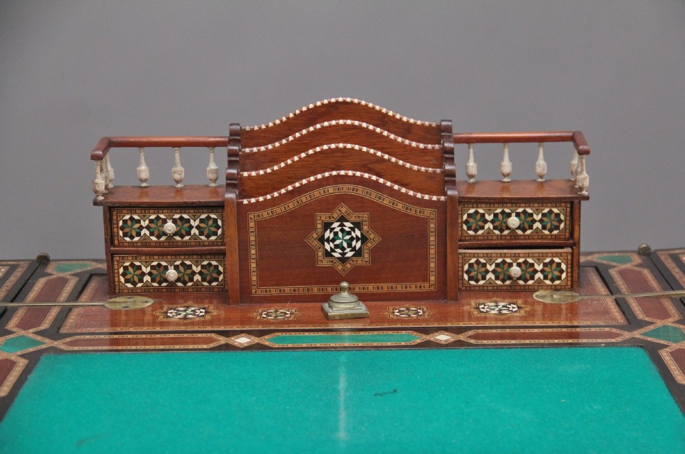 A 19th-century Syrian metamorphic writing table with geometric mother-of-pearl inlay, side flap leaves, and a green writing surface. View XV
