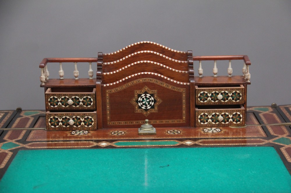 A 19th-century Syrian metamorphic writing table with geometric mother-of-pearl inlay, side flap leaves, and a green writing surface. View XVI