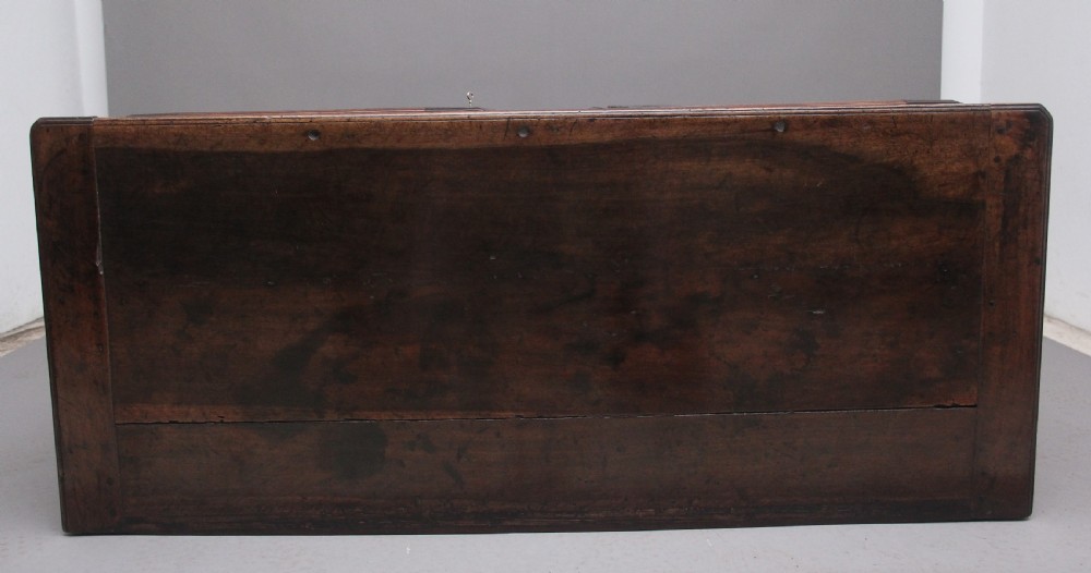 An early nineteenth-century French cherrywood dresser base featuring two cupboard doors with shaped panels, central fluting, decorative brass escutcheons, and short cabriole legs. View VI