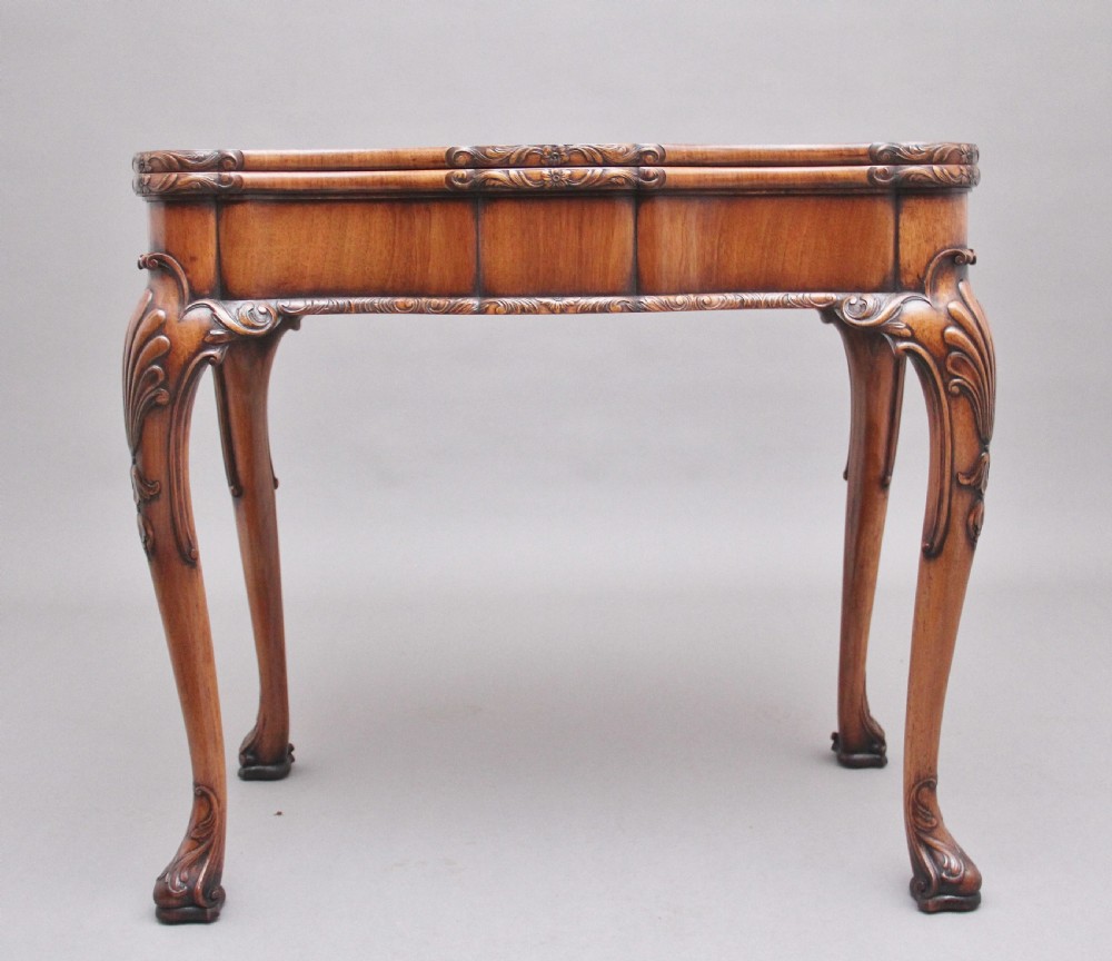An early twentieth-century carved walnut card table featuring cabriole legs with shell motifs and a contoured apron. View II
