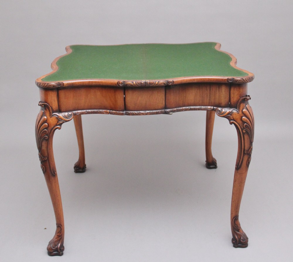 An early twentieth-century carved walnut card table featuring cabriole legs with shell motifs and a contoured apron. View V