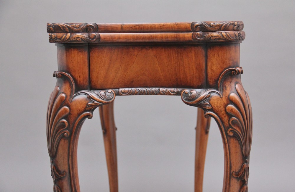 An early twentieth-century carved walnut card table featuring cabriole legs with shell motifs and a contoured apron. View VI