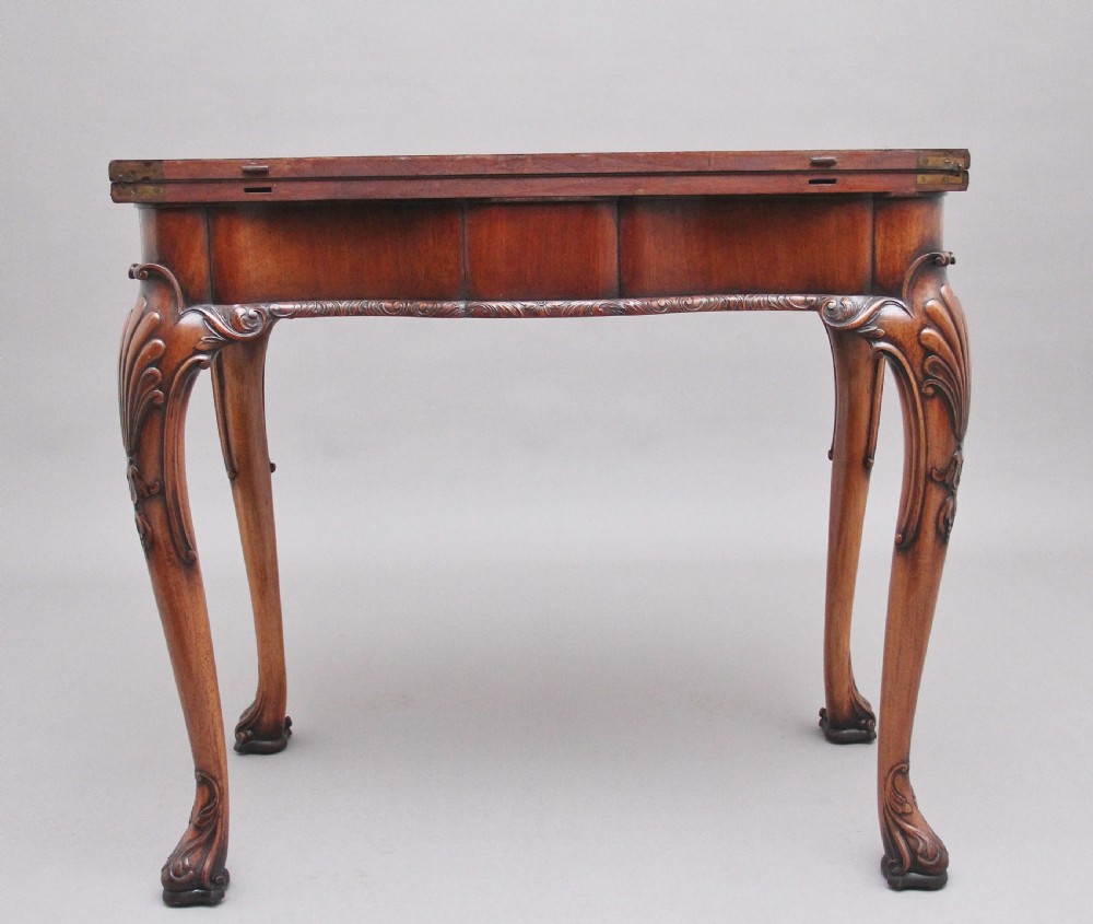 An early twentieth-century carved walnut card table featuring cabriole legs with shell motifs and a contoured apron. View VIII
