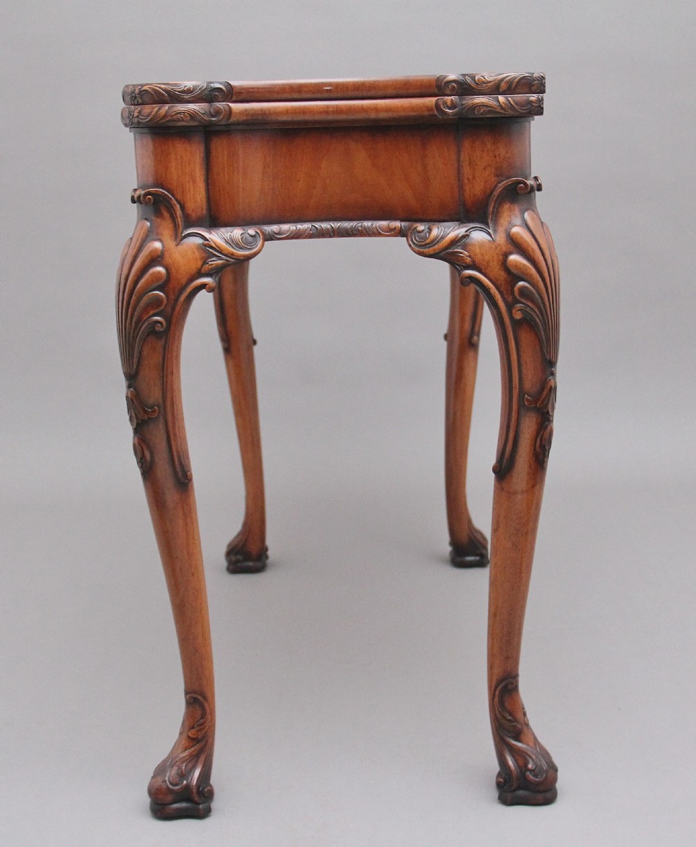 An early twentieth-century carved walnut card table featuring cabriole legs with shell motifs and a contoured apron. View IX