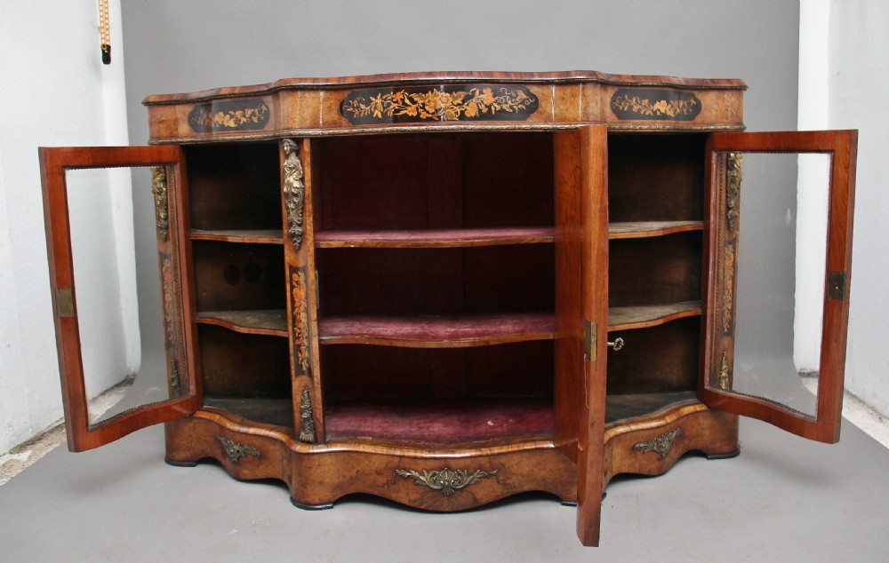 A 19th-century burr walnut credenza featuring a central door with floral marquetry inlay, flanked by two curved glazed doors and detailed ormolu mounts. View VII
