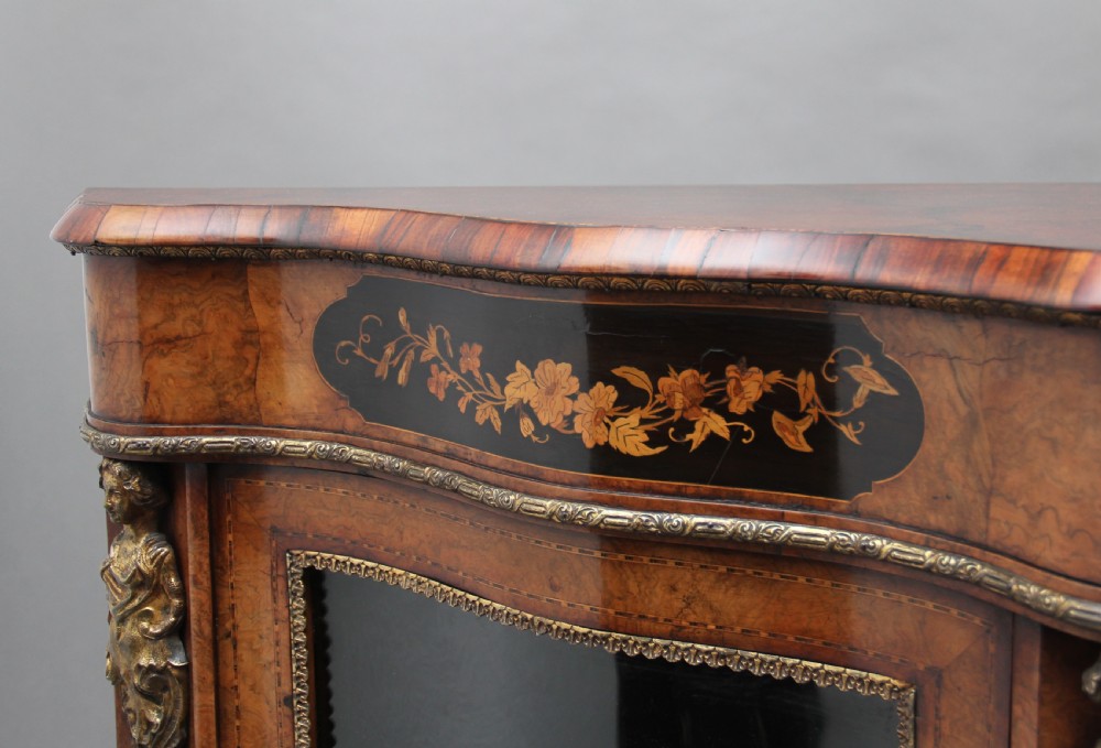 A 19th-century burr walnut credenza featuring a central door with floral marquetry inlay, flanked by two curved glazed doors and detailed ormolu mounts. View XI