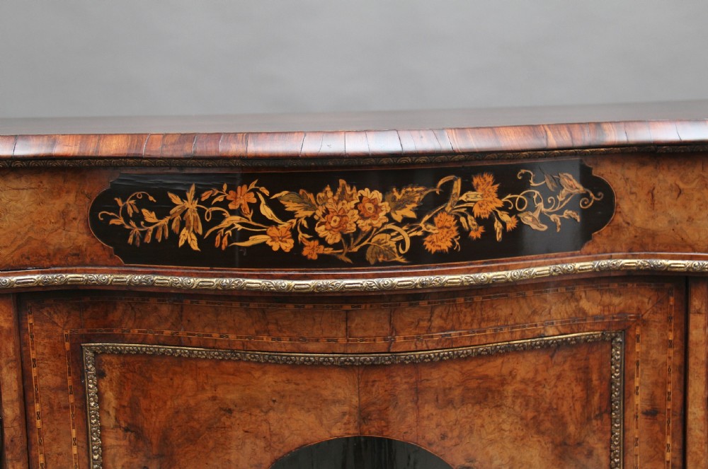 A 19th-century burr walnut credenza featuring a central door with floral marquetry inlay, flanked by two curved glazed doors and detailed ormolu mounts. View XIII