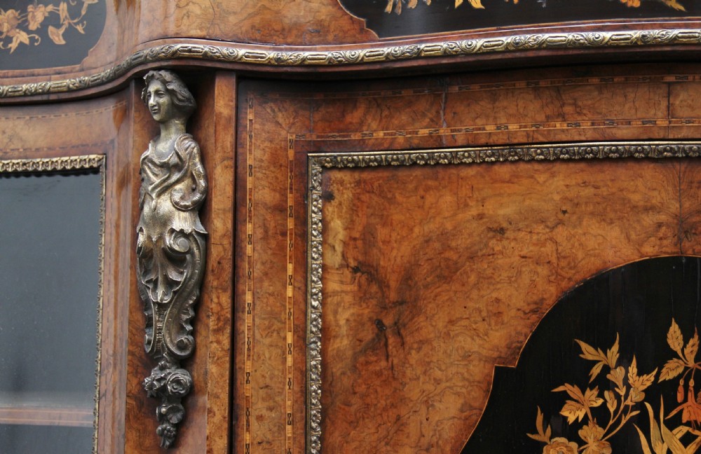 A 19th-century burr walnut credenza featuring a central door with floral marquetry inlay, flanked by two curved glazed doors and detailed ormolu mounts. View XV