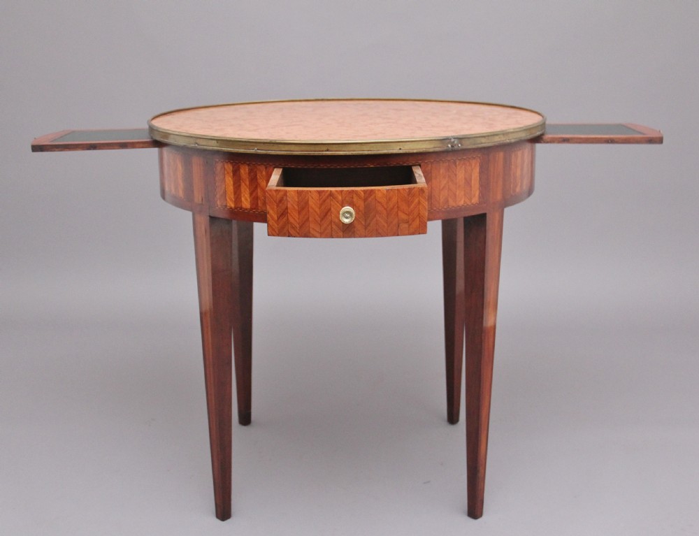 A 19th-century French oval centre table featuring kingwood parquetry, tapered square legs, a single drawer, and a brass gallery top rim. View III