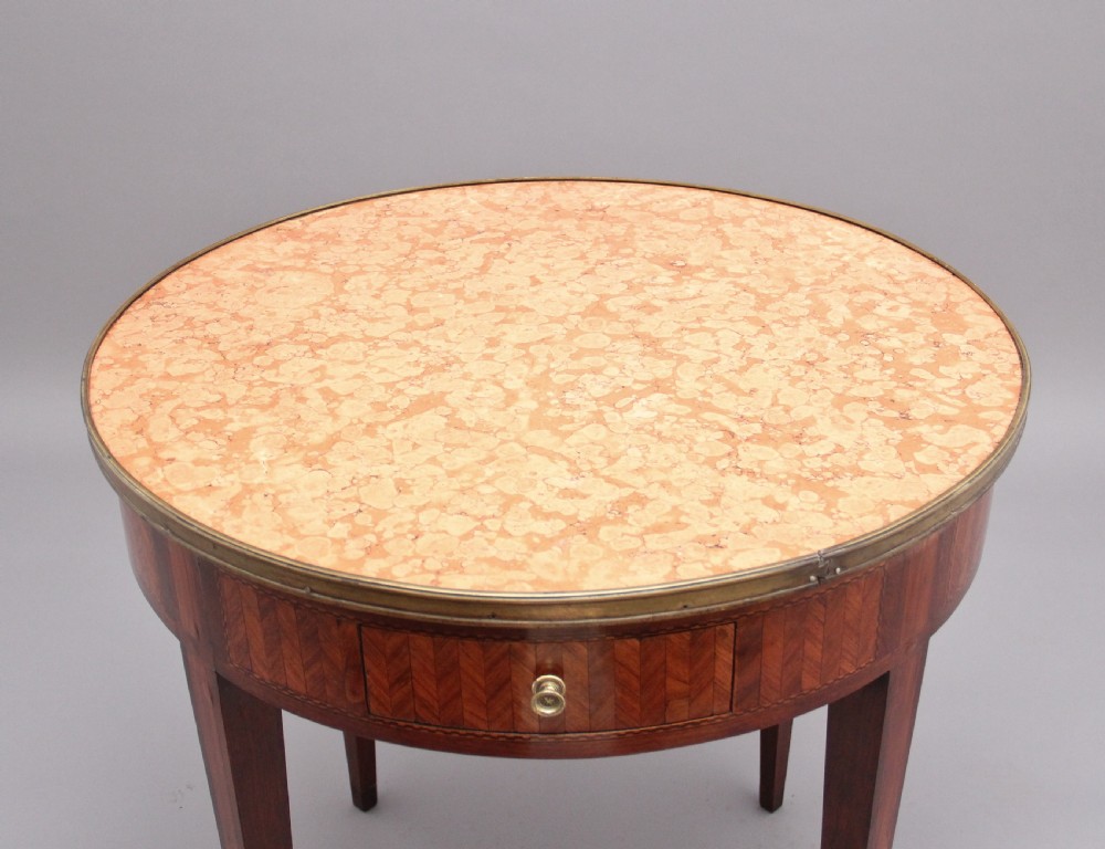 A 19th-century French oval centre table featuring kingwood parquetry, tapered square legs, a single drawer, and a brass gallery top rim. View V