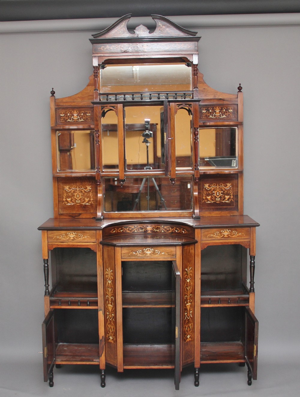 A 19th-century rosewood display cabinet featuring intricate marquetry urn inlays, mirror backs, lattice glazed doors, and a broken pediment top. View II