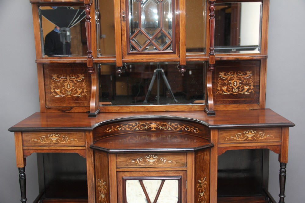 A 19th-century rosewood display cabinet featuring intricate marquetry urn inlays, mirror backs, lattice glazed doors, and a broken pediment top. View V