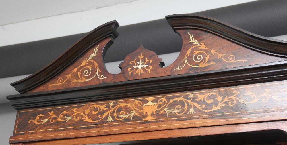A 19th-century rosewood display cabinet featuring intricate marquetry urn inlays, mirror backs, lattice glazed doors, and a broken pediment top. View XII