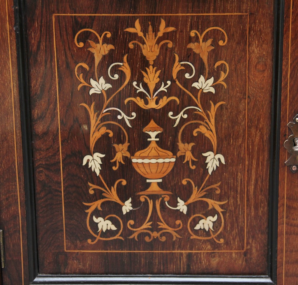 A 19th-century rosewood display cabinet featuring intricate marquetry urn inlays, mirror backs, lattice glazed doors, and a broken pediment top. View XIII