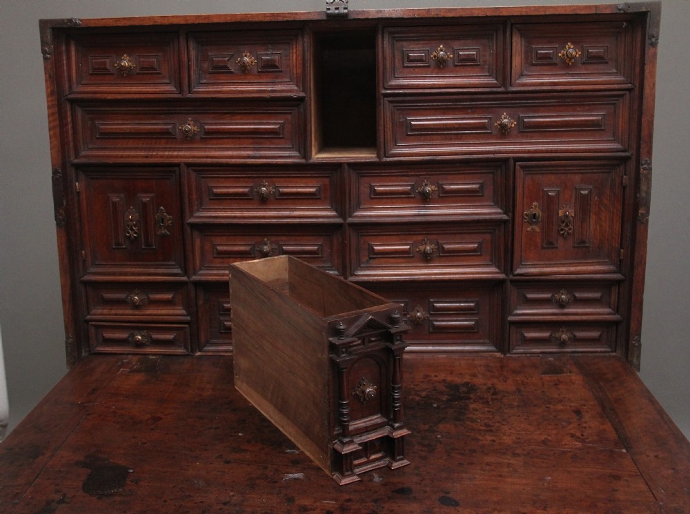 A seventeenth-century Spanish walnut vargueno writing cabinet featuring intricate wrought iron lockplates and handles resting on a turned trestle stand. View VIII