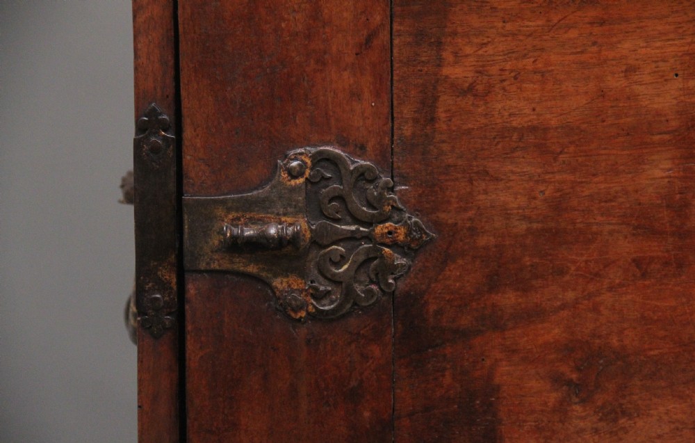 A seventeenth-century Spanish walnut vargueno writing cabinet featuring intricate wrought iron lockplates and handles resting on a turned trestle stand. View XIII