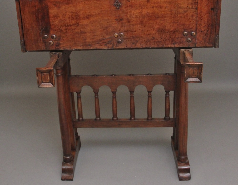 A seventeenth-century Spanish walnut vargueno writing cabinet featuring intricate wrought iron lockplates and handles resting on a turned trestle stand. View XV