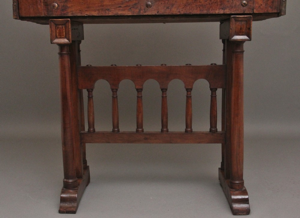 A seventeenth-century Spanish walnut vargueno writing cabinet featuring intricate wrought iron lockplates and handles resting on a turned trestle stand. View XVI