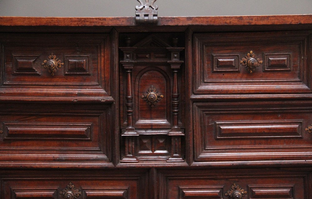 A seventeenth-century Spanish walnut vargueno writing cabinet featuring intricate wrought iron lockplates and handles resting on a turned trestle stand. View XVII