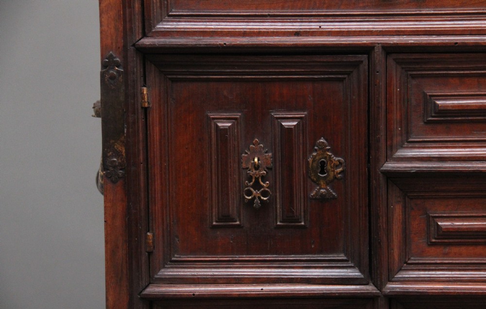 A seventeenth-century Spanish walnut vargueno writing cabinet featuring intricate wrought iron lockplates and handles resting on a turned trestle stand. View XVIII