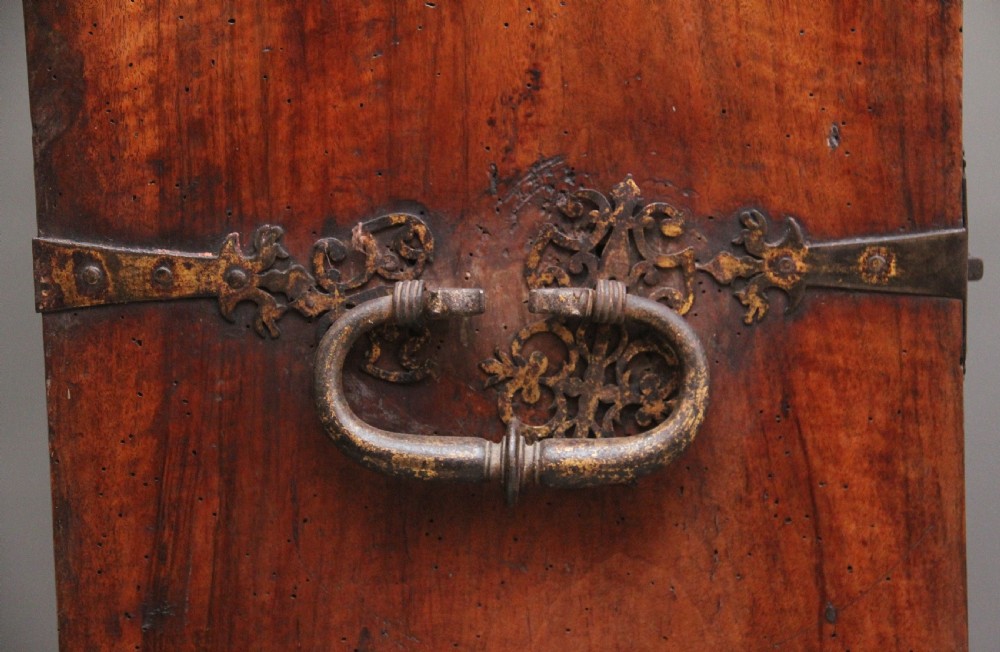 A seventeenth-century Spanish walnut vargueno writing cabinet featuring intricate wrought iron lockplates and handles resting on a turned trestle stand. View XXII