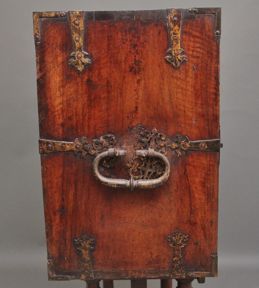 A seventeenth-century Spanish walnut vargueno writing cabinet featuring intricate wrought iron lockplates and handles resting on a turned trestle stand. View XXIII