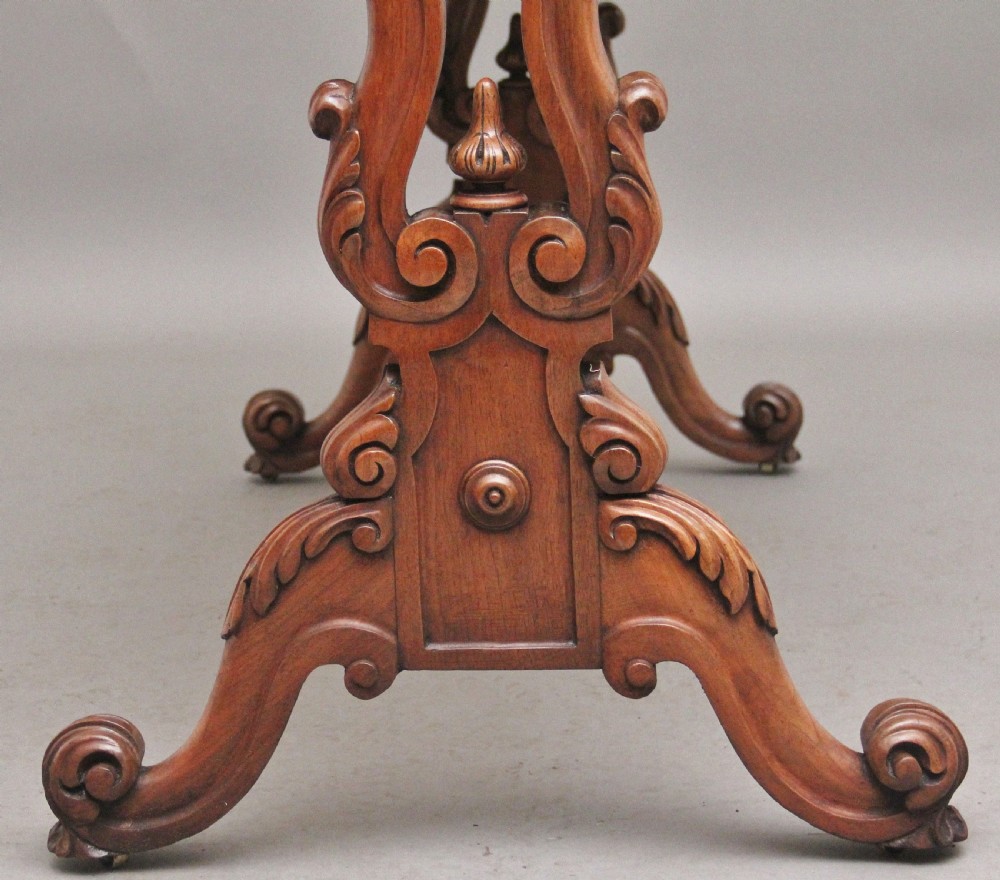 A 19th-century burr walnut centre table featuring a serpentine top and elaborate carved scroll supports joined by a turned stretcher. View VII
