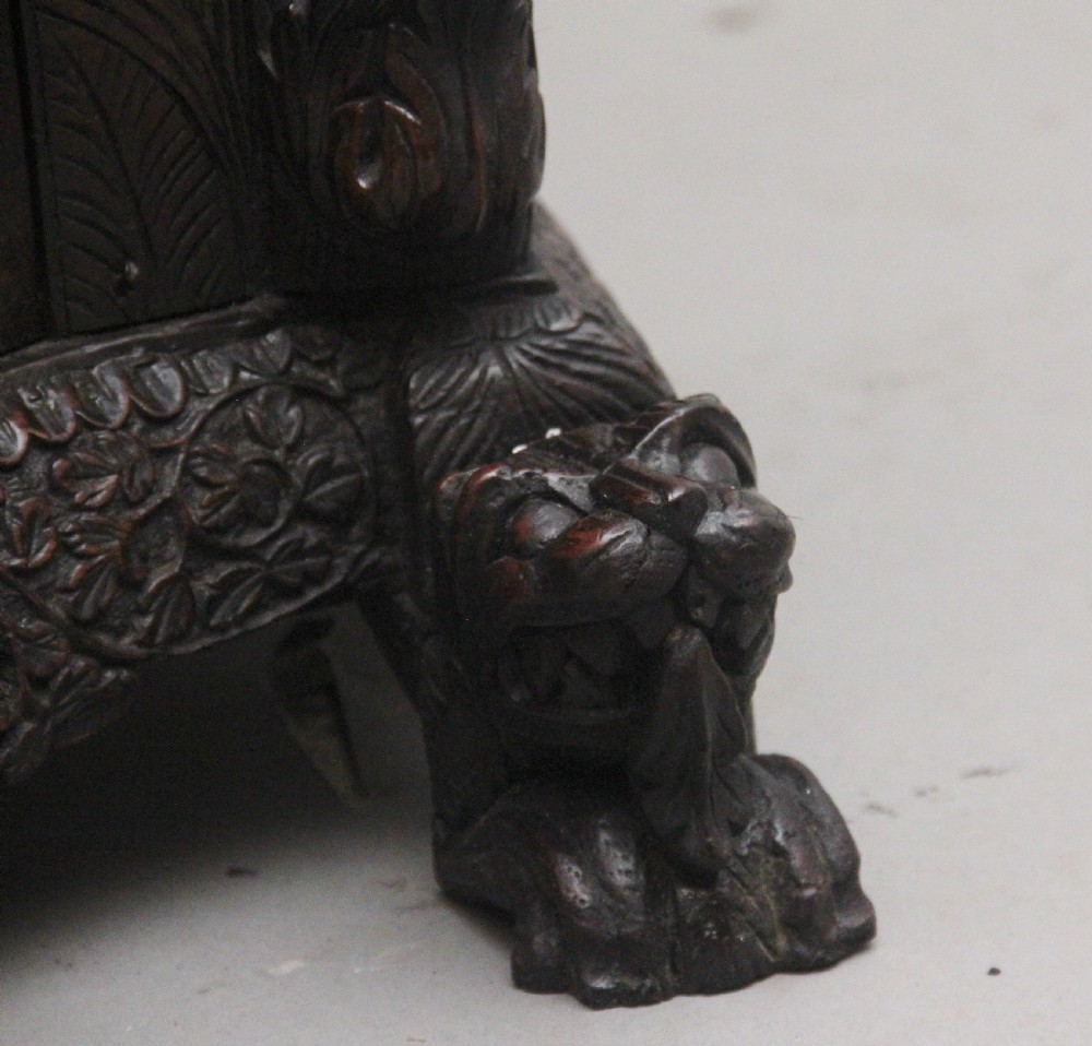 A 19th-century dark wood Anglo-Indian cabinet featuring intricate pierced floral carving, an arched panel door, and carved lion feet. View XVIII