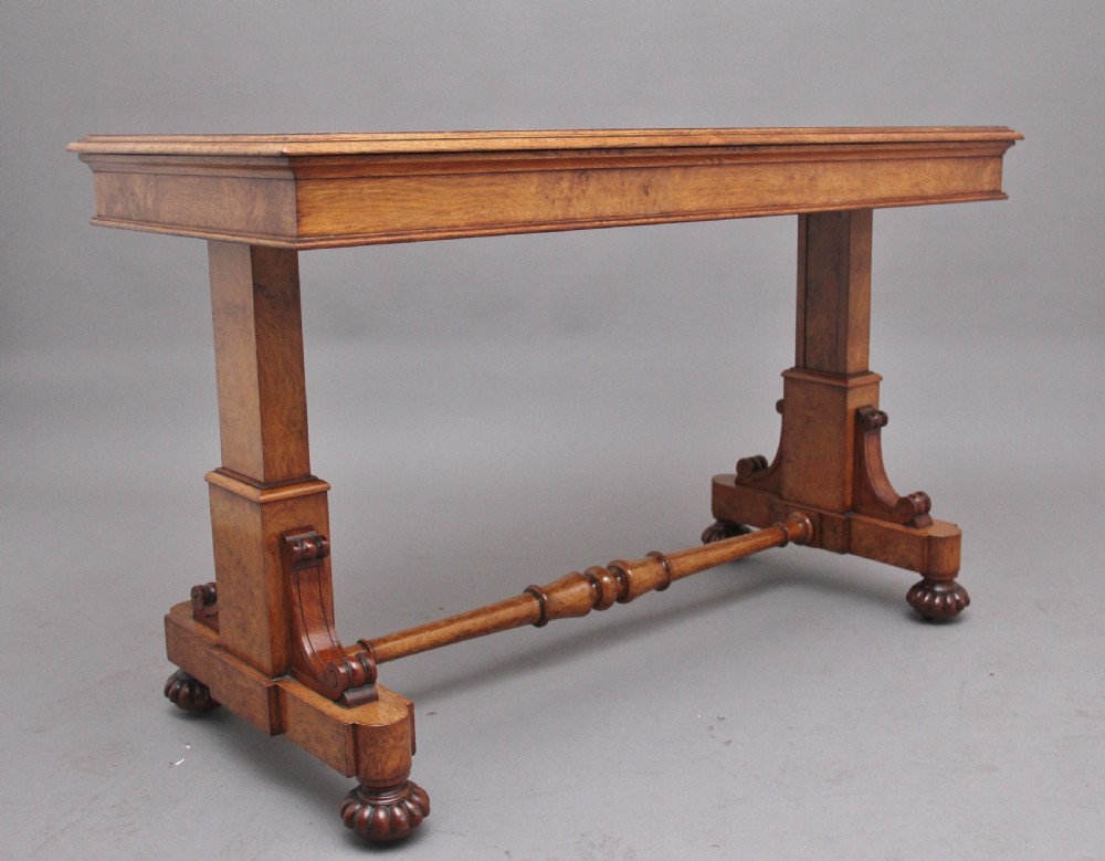 An early 19th-century pollard oak dumb waiter featuring three rectangular tiered shelves supported by upright pillars and a carved trestle base with lobed feet. View II