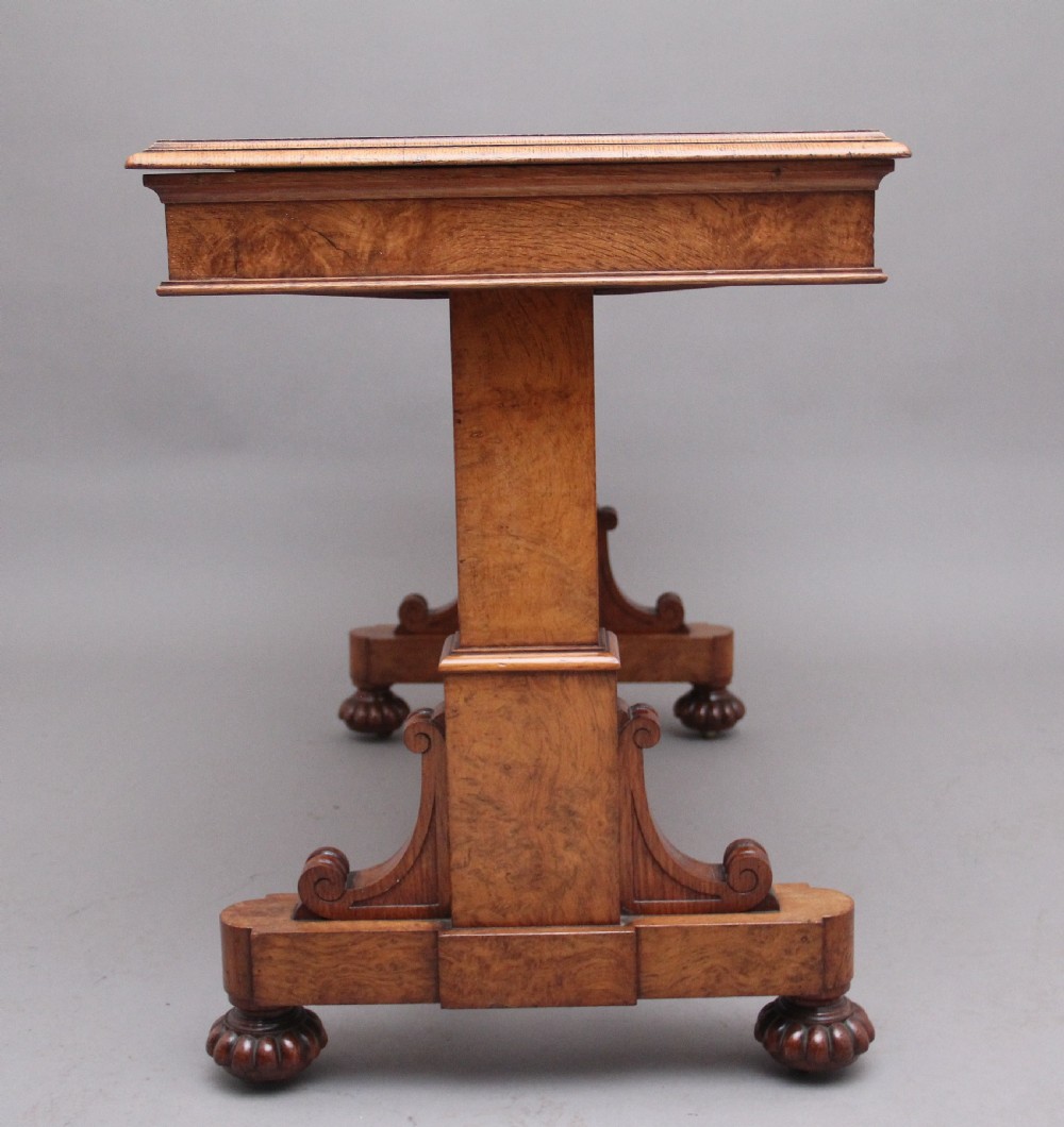 An early 19th-century pollard oak dumb waiter featuring three rectangular tiered shelves supported by upright pillars and a carved trestle base with lobed feet. View V