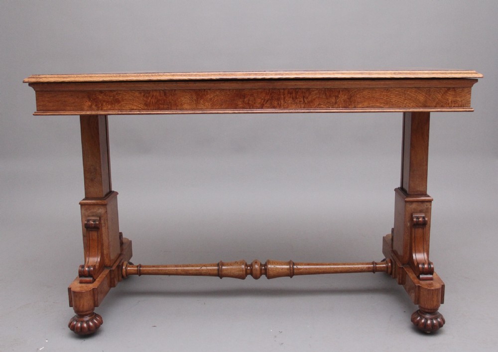 An early 19th-century pollard oak dumb waiter featuring three rectangular tiered shelves supported by upright pillars and a carved trestle base with lobed feet. View VII