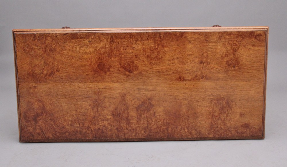 An early 19th-century pollard oak dumb waiter featuring three rectangular tiered shelves supported by upright pillars and a carved trestle base with lobed feet. View IX