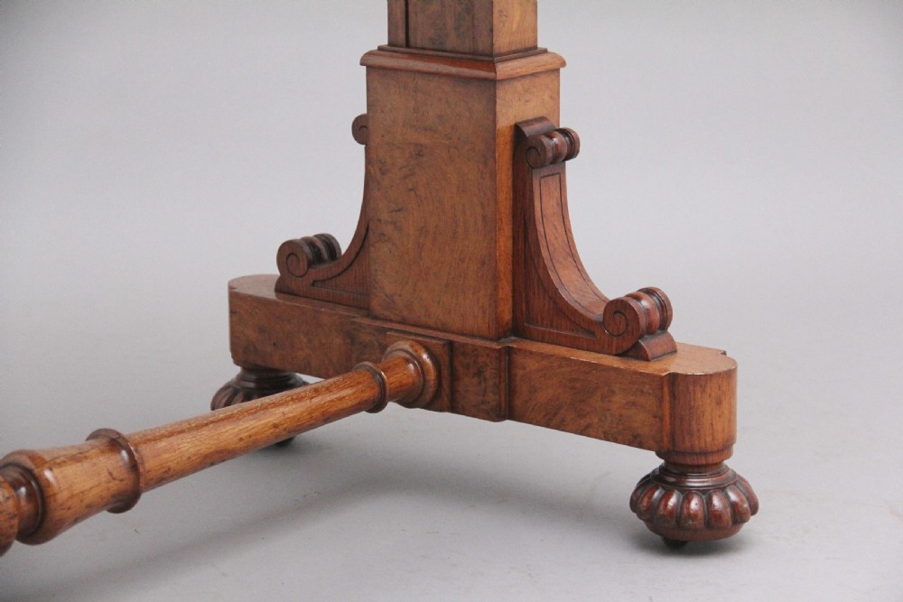 An early 19th-century pollard oak dumb waiter featuring three rectangular tiered shelves supported by upright pillars and a carved trestle base with lobed feet. View XI