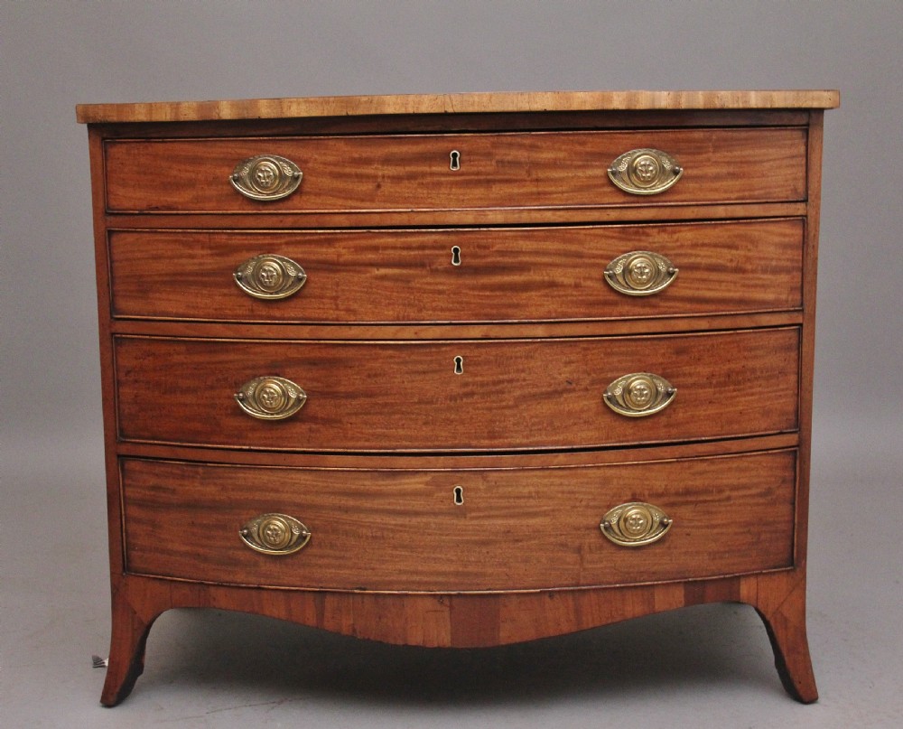 A nineteenth-century mahogany bowfront chest of drawers featuring four graduated drawers with oval brass handles and splayed feet.