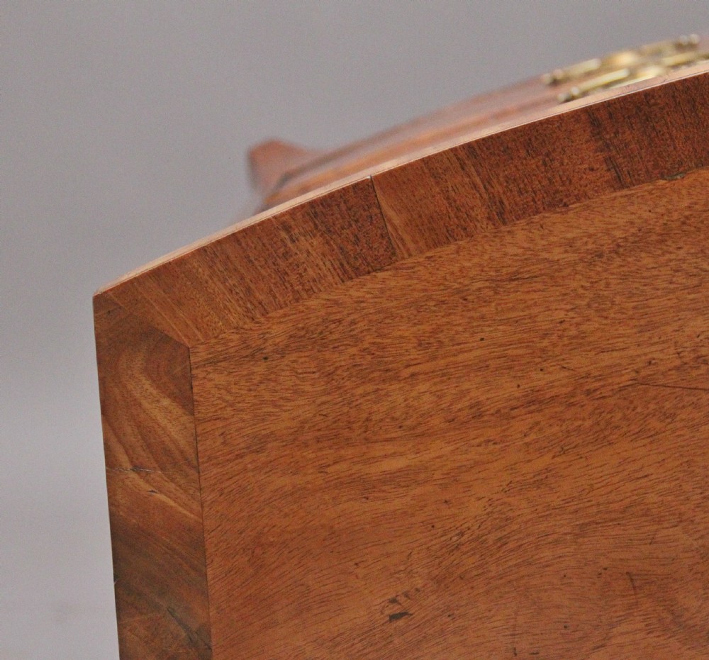 A nineteenth-century mahogany bowfront chest of drawers featuring four graduated drawers with oval brass handles and splayed feet. View XI